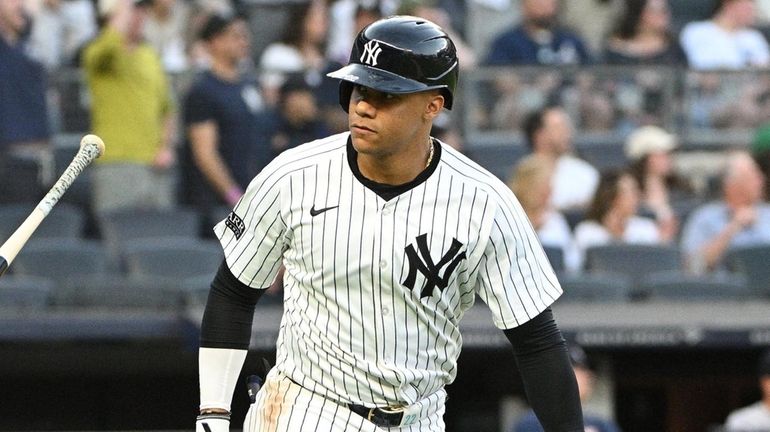 Yankees’ Juan Soto tosses his bat and looks to the...