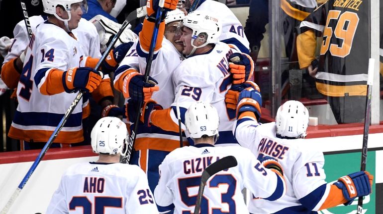 The Islanders celebrate a 4-3 overtime victory over the Penguins during...