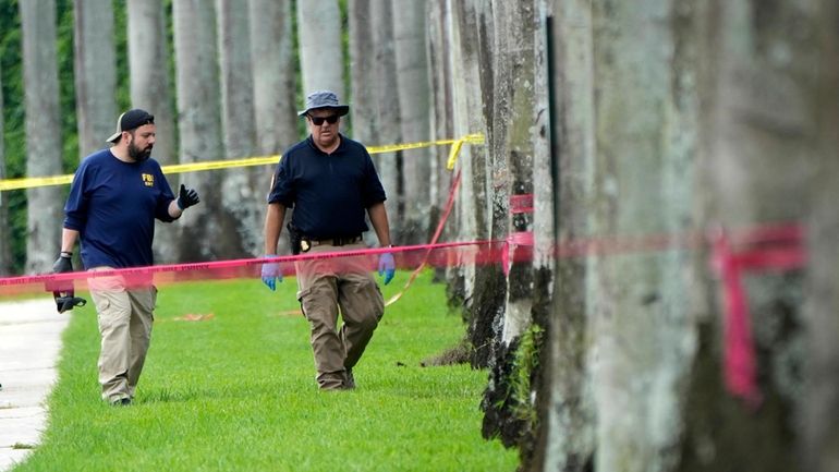 Law enforcement officials work outside of the Trump International Golf...