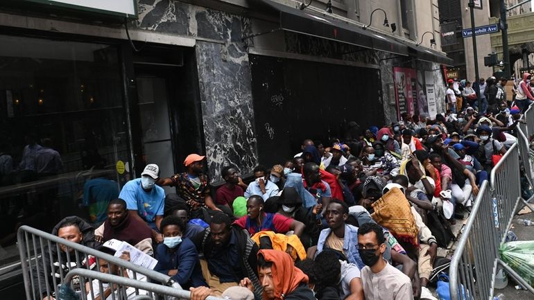 An overflow of foreign migrants outside New York City's main...