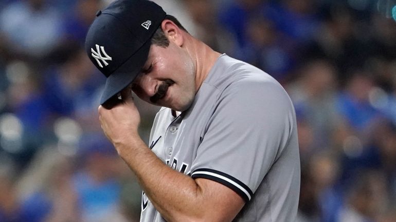 Carlos Rodon of the New York Yankees reacts after walking Logan...