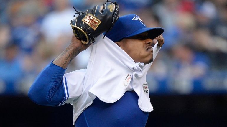 Blue Jays starting pitcher Marcus Stroman takes off his jersey...