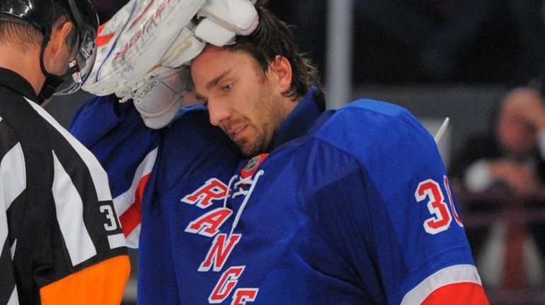 Rangers goalie Henrik Lundqvist and referee Dean Morton inspect Lundqvist's...