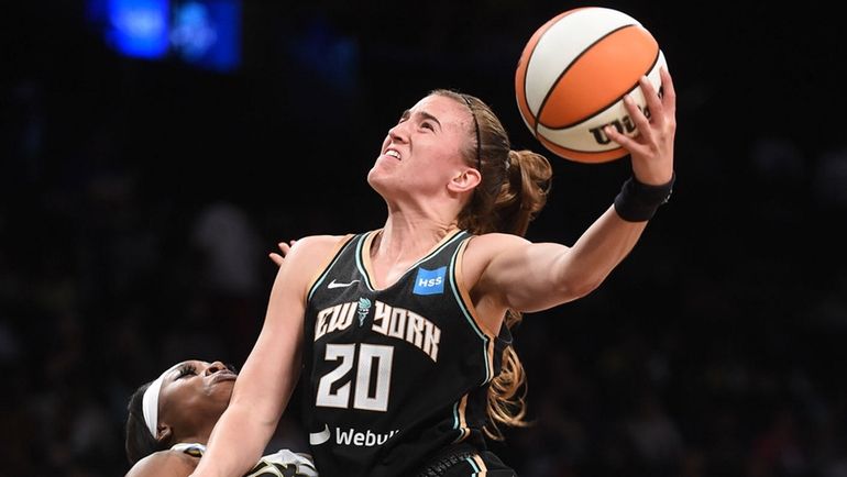 Sabrina Ionescu of the Liberty, right, looks to score from close range...