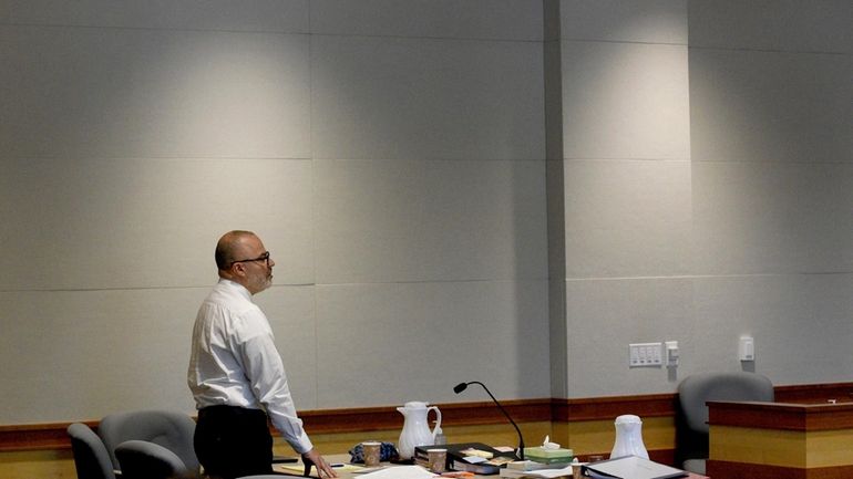 Victor Malavet stands as lawyers conduct a bench meeting with...