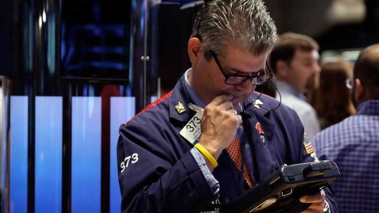 Trader John Panin works on the floor of the New...