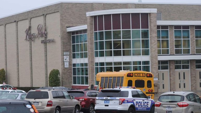 Suffolk County police officers patrol outside Kings Park High School...