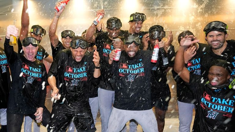 The Miami Marlins celebrate in the locker room after clinching...