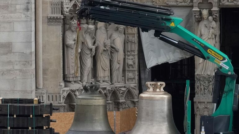 A truck carrying bells is parked outside Notre-Dame de Paris...