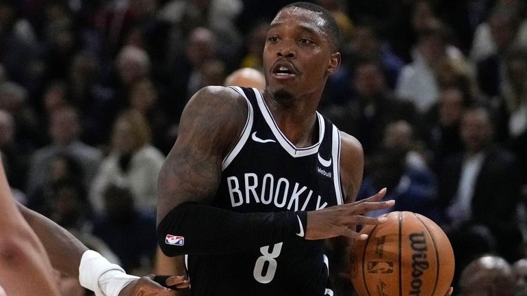 Nets' Lonnie Walker IV, left, drives the ball during the...