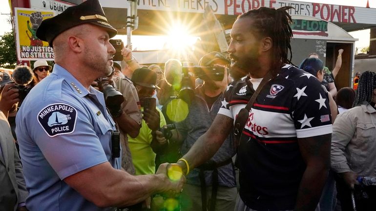 Minneapolis Police Chief Brian O'Hara, left, shakes hands with Michael...