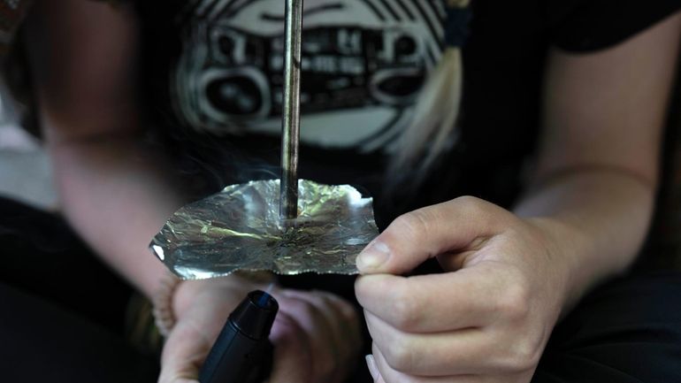 A homeless woman person smokes fentanyl, June 28, 2024, in...