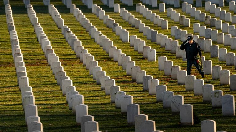 A man salutes after placing a wreath at Arlington National...