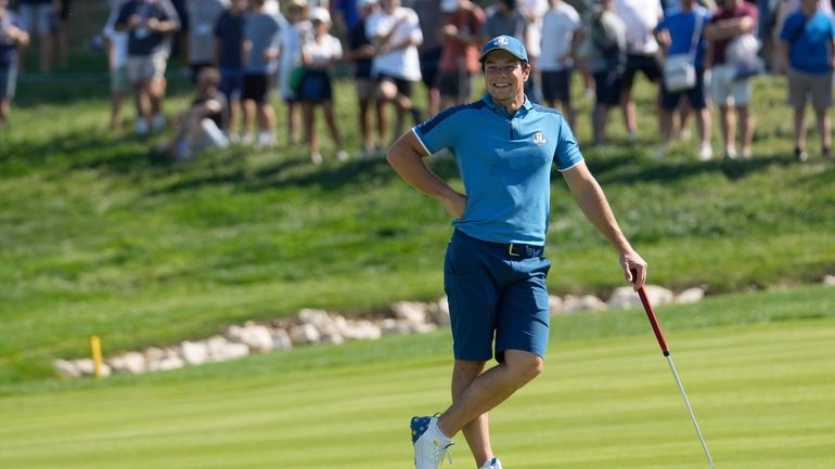 Europe's Viktor Hovland smiles as he waits to putt on...