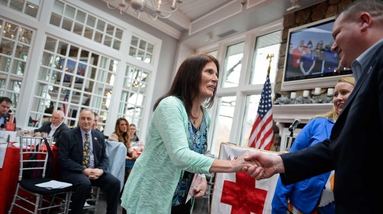 Doreen Brienza, of Port Jefferson Station, left, shakes hands with...