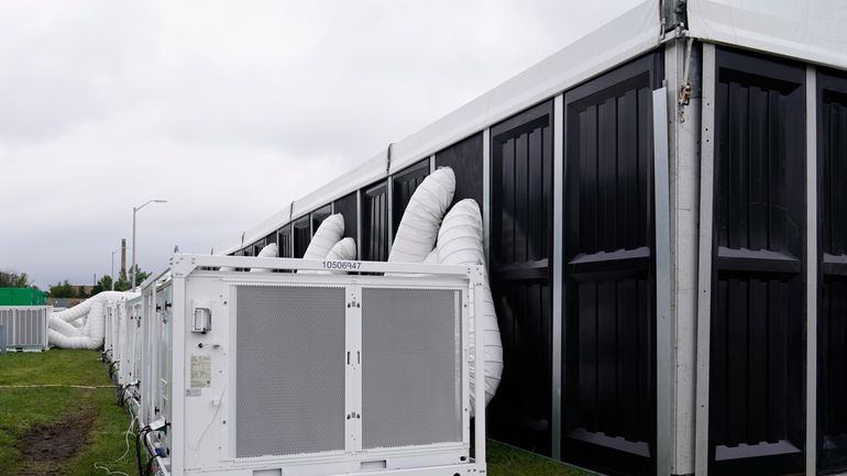 Large air conditioners are seen outside the dormitory tent during...