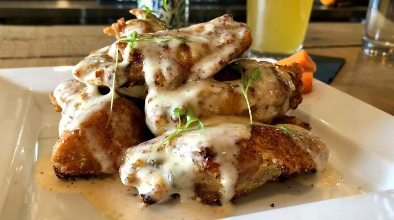 The wings at Social Gastropub in Old Bethpage are tossed...