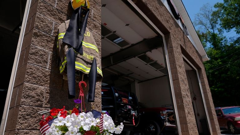 Flowers and a tribute to fallen firefighter Corey Comperatore are...