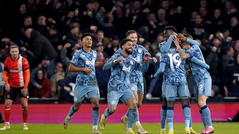 Aston Villa's Lucas Digne, right, is congratulated by his team...