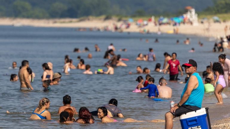 Beachgoers cool off in the Long Island Sound waters at...