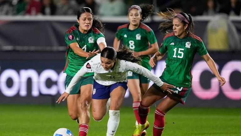 United States forward Sophia Smith, front, falls while vying for...