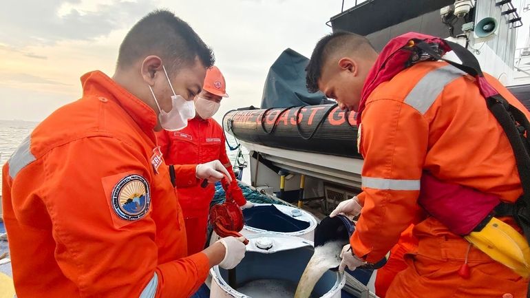 In this photo provided by the Philippine Coast Guard, Philippine...