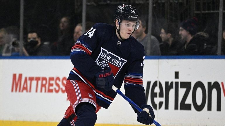 Rangers right wing Kaapo Kakko skates with the puck against...