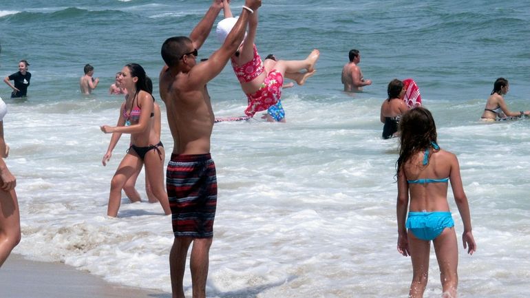 Beachgoers play in the surf in Ship Bottom, N.J. on...