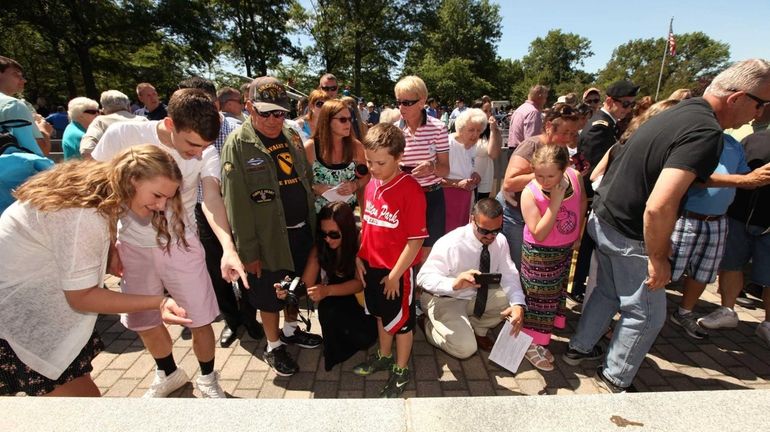 People look at new panels engraved with 240 names that...