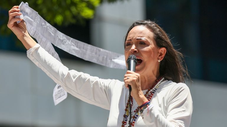 Opposition leader Maria Corina Machado displays vote tally sheets during...