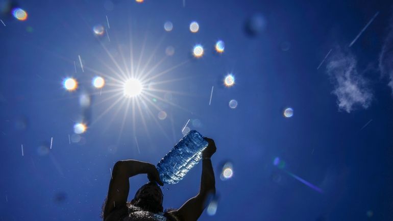 A man pours cold water onto his head to cool...