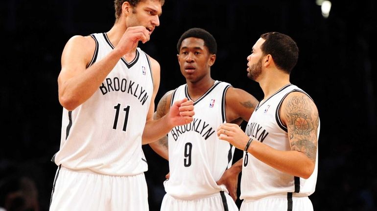 Brook Lopez, MarShon Brooks and Deron Williams go over a...