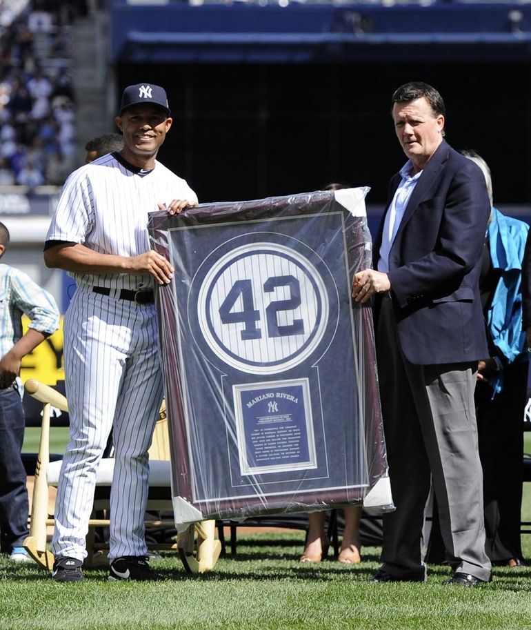 New York Yankees pitcher Mariano Rivera, left, waves to the crowd after  accepting a check for the Mariano Rivera Foundation from Seattle Mariners'  former designated hitter Edgar Martinez, right, prior to a