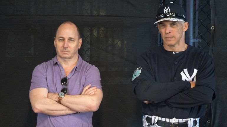 Yankees GM Brian Cashman watches a bullpen session with manager...