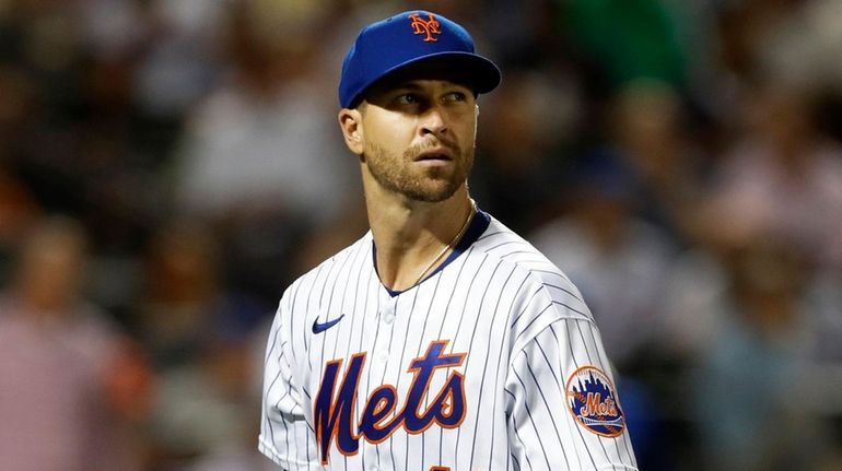 Jacob deGrom of the Mets walks to the dugout after the...