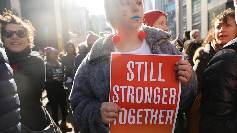 Thousands hold signs and rally while attending the Women's March...