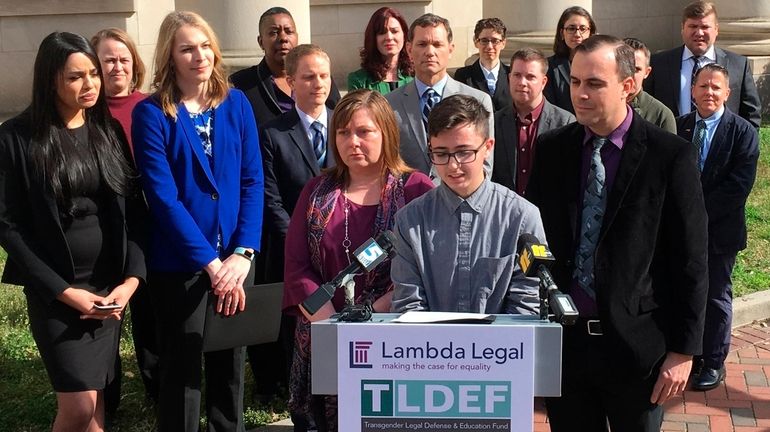 Connor Thonen-Fleck addresses reporters while his parents stand by his...