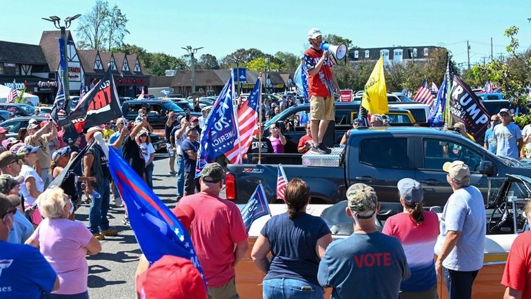 Shawn Farash uses a loudspeaker to address a crowd at a...