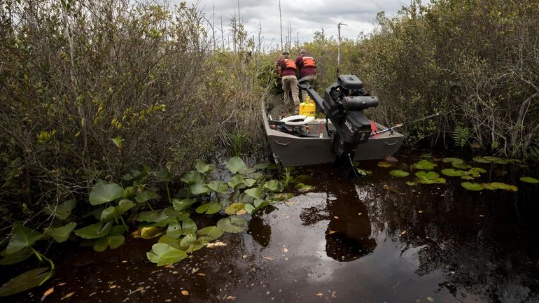 Okefenokee National Wildlife Refuge maintenance crew leader Pete Chesser, right,...