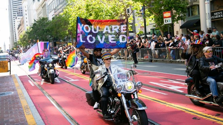 Bikers, center, ride a Harley Davidson motorcycle in the annual...