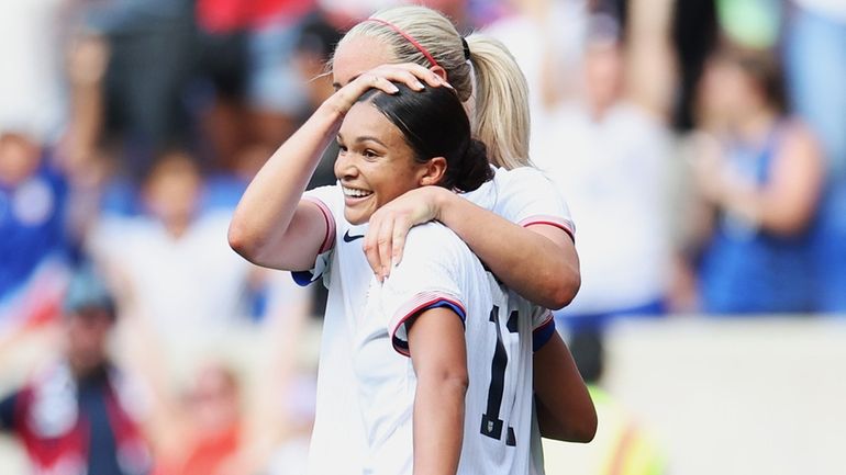 Lindsey Horan and Sophia Smith of the United States react after a...