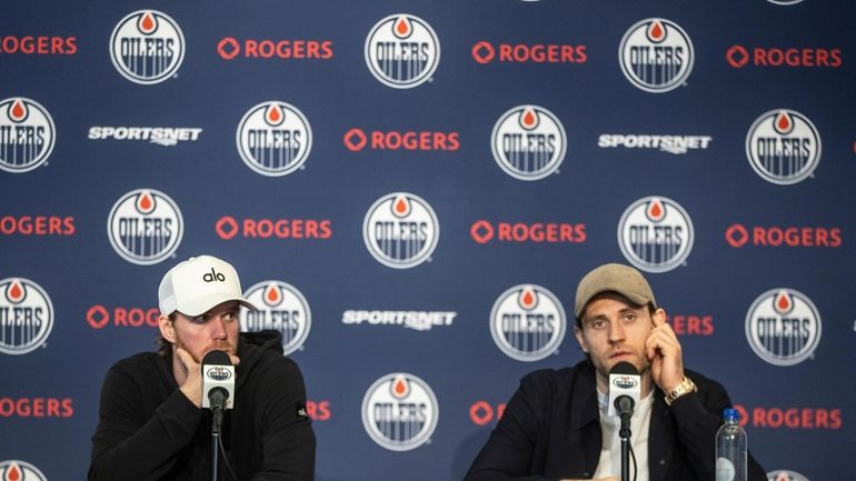 Edmonton Oilers' Connor McDavid, left and Leon Draisaitl speak during...
