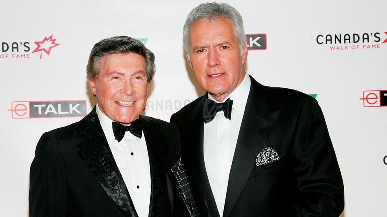 "Jeopardy!" presenter Johnny Gilbert, left, and host Alex Trebek, seen in...