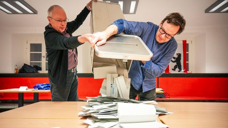 Poll workers empty the ballot boxes at polling station 317...