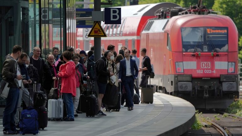 Travellers wait on a platform as a train leaves the...