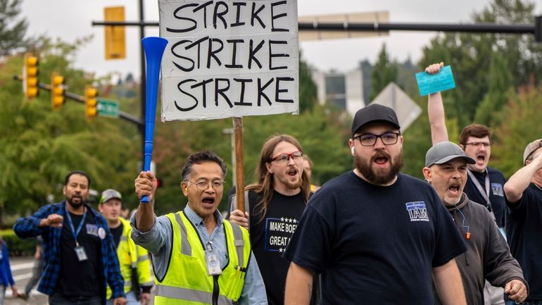 International Aerospace Machinists union members march toward the union's hall...