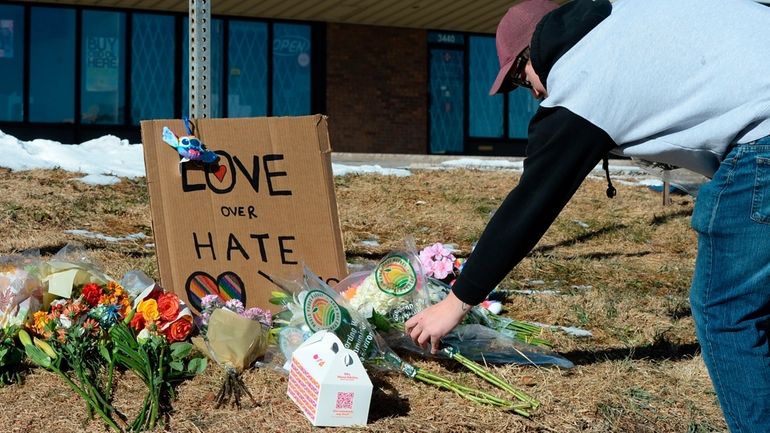 A mourner lays flowers outside a club serving an LGBTQ...