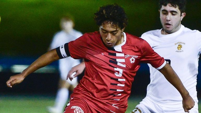 Connetquot's Nicolas Maldonado, left, shields the ball from McQuaid's Marco...