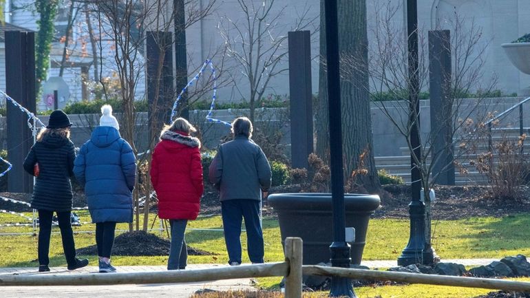 People walk in Heckscher Park in Huntington on the second...