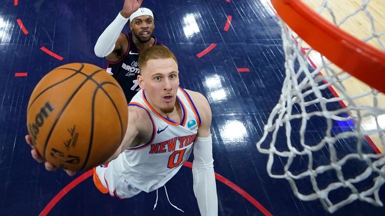 The Knicks' Donte DiVincenzo, right, goes up for a shot...